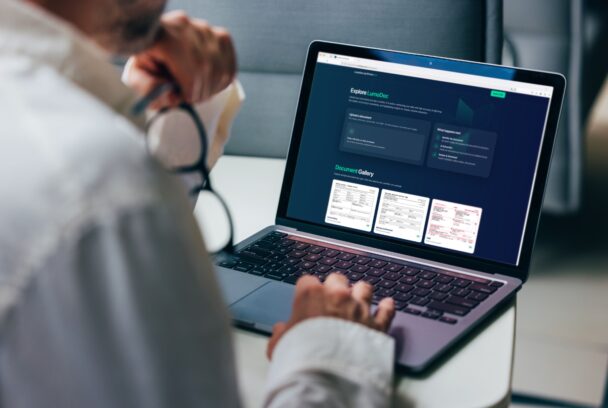 A professional focuses on analyzing detailed business reports displayed on a laptop screen. The graphics include various charts and performance metrics, highlighting statistical trends for comprehensive decision-making in a corporate environment.