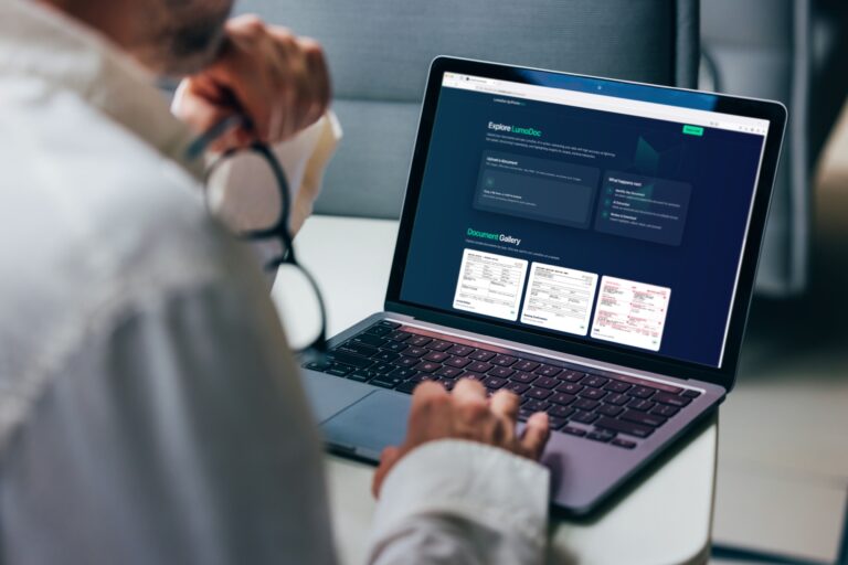 A professional focuses on analyzing detailed business reports displayed on a laptop screen. The graphics include various charts and performance metrics, highlighting statistical trends for comprehensive decision-making in a corporate environment.